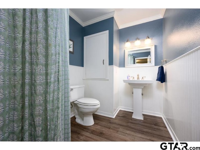 bathroom featuring hardwood / wood-style floors, crown molding, and toilet