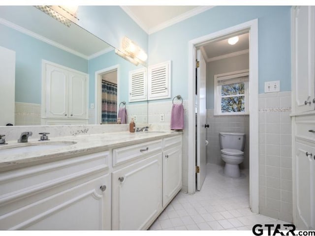 bathroom with toilet, crown molding, tile patterned floors, vanity, and tile walls