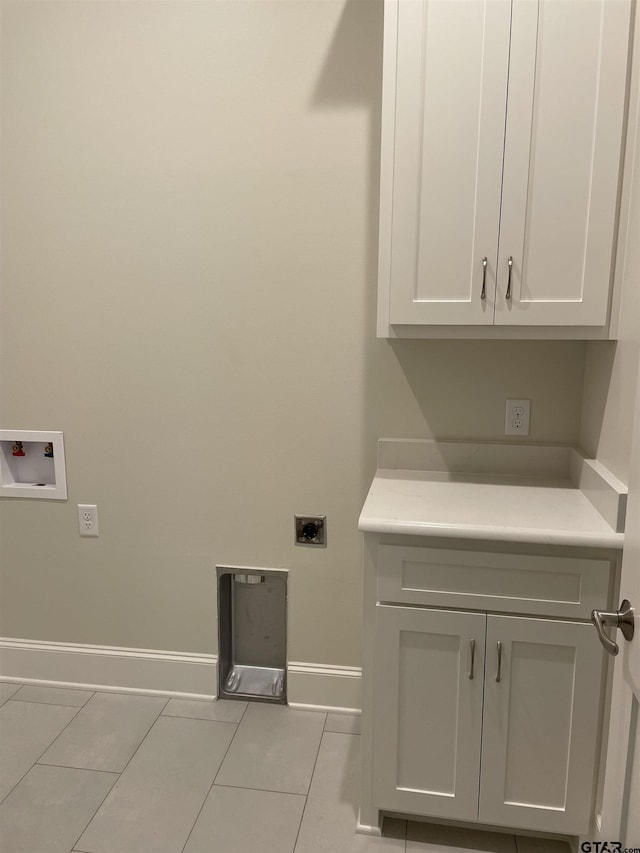 clothes washing area featuring hookup for an electric dryer, cabinets, light tile patterned floors, and hookup for a washing machine