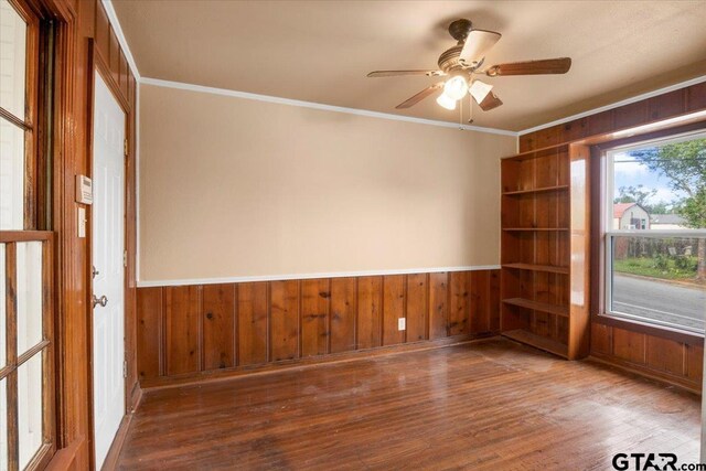 1330 Graham Dr, Tyler, TX 75701 - unfurnished room with wood finished floors, a wainscoted wall, ceiling fan, wooden walls, and ornamental molding