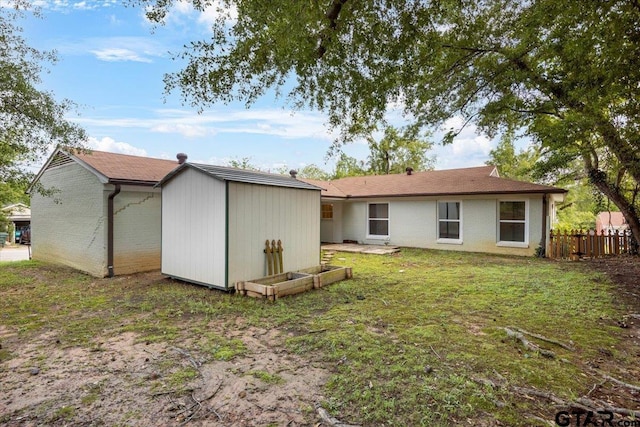 1330 Graham Dr, Tyler, TX 75701 - rear view of house with an outbuilding, a storage unit, fence, a lawn, and brick siding