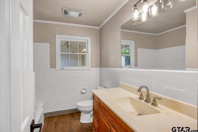 1330 Graham Dr, Tyler, TX 75701 - bathroom with tile walls, toilet, visible vents, vanity, and wood finished floors