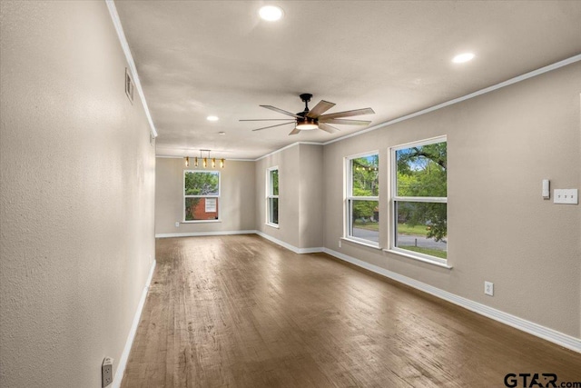 1330 Graham Dr, Tyler, TX 75701 - empty room with ceiling fan with notable chandelier, wood finished floors, ornamental molding, visible vents, and baseboards