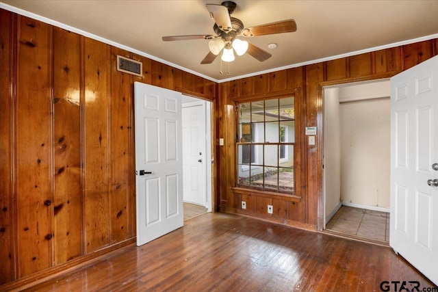 1330 Graham Dr, Tyler, TX 75701 - foyer entrance featuring ceiling fan, ornamental molding, wood walls, and visible vents