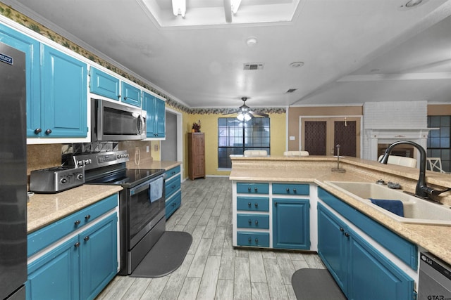 kitchen with stainless steel appliances, blue cabinetry, sink, ceiling fan, and light hardwood / wood-style flooring