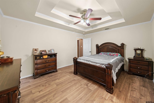 bedroom with a tray ceiling, ceiling fan, and light hardwood / wood-style flooring