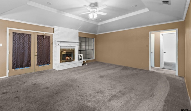 unfurnished living room with a fireplace, ceiling fan, a raised ceiling, and carpet floors