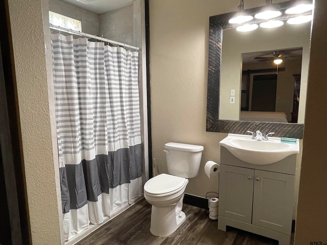 bathroom with toilet, vanity, wood-type flooring, and walk in shower