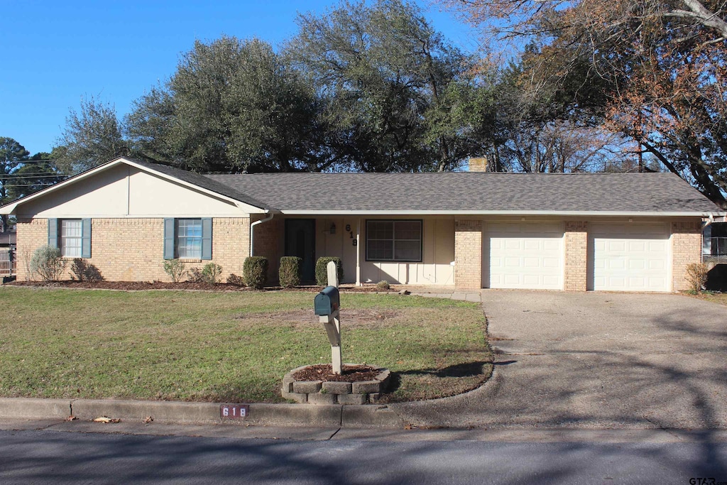 single story home featuring a garage and a front lawn