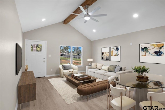 living room with ceiling fan, high vaulted ceiling, beamed ceiling, and light wood-type flooring