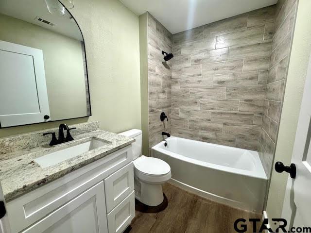 641 N Weldon St, Frankston, TX 75763 - full bath featuring wood finished floors, toilet, vanity, and bathtub / shower combination