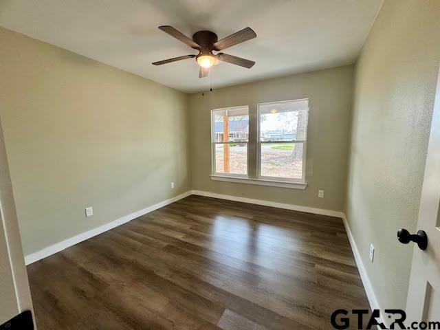 641 N Weldon St, Frankston, TX 75763 - empty room featuring ceiling fan, dark wood-type flooring, and baseboards