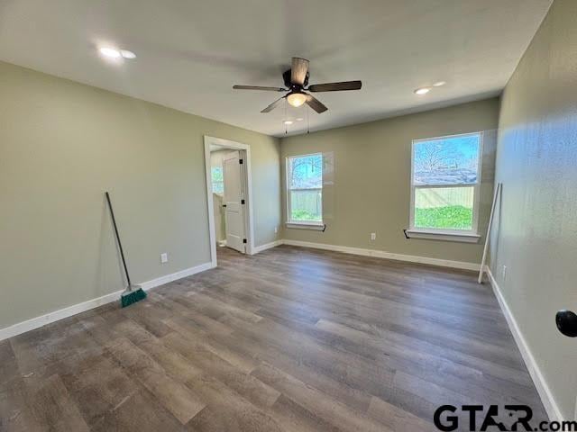 unfurnished room with ceiling fan, plenty of natural light, and dark hardwood / wood-style floors