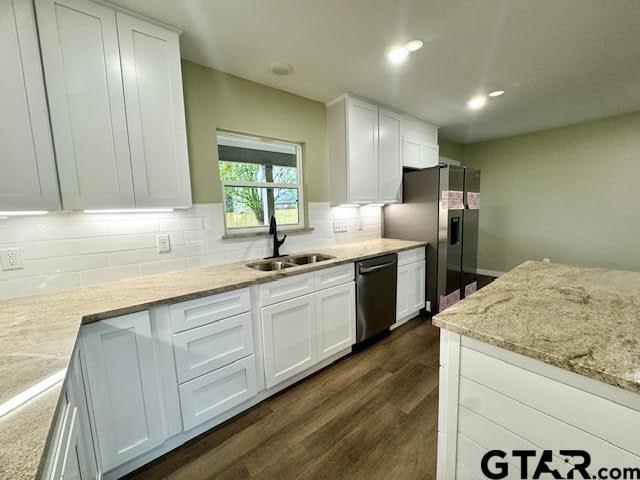 641 N Weldon St, Frankston, TX 75763 - kitchen with black dishwasher, a sink, white cabinetry, backsplash, and dark wood-style floors