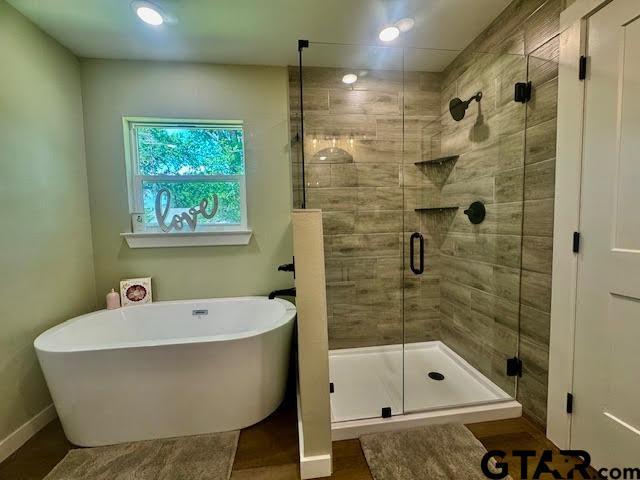 641 N Weldon St, Frankston, TX 75763 - bathroom with a soaking tub, a shower stall, and baseboards