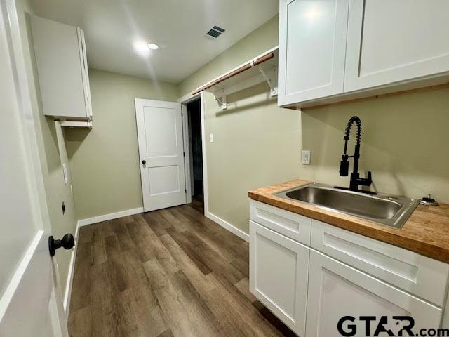 641 N Weldon St, Frankston, TX 75763 - laundry area with a sink, dark wood finished floors, and baseboards