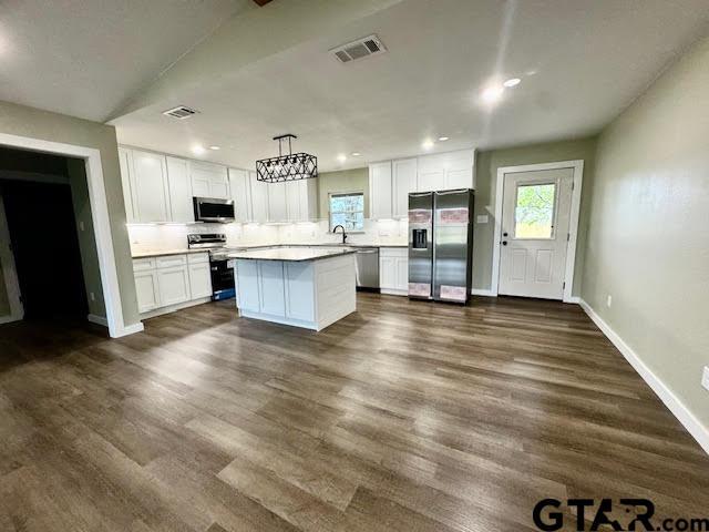641 N Weldon St, Frankston, TX 75763 - kitchen featuring stainless steel appliances, white cabinetry, baseboards, a kitchen island, and a sink