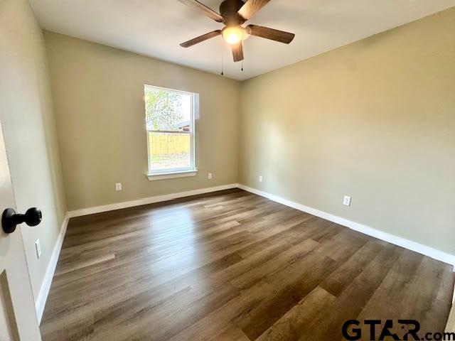 641 N Weldon St, Frankston, TX 75763 - empty room featuring ceiling fan, dark wood finished floors, and baseboards