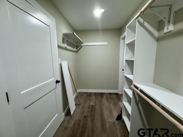 spacious closet with dark wood-type flooring