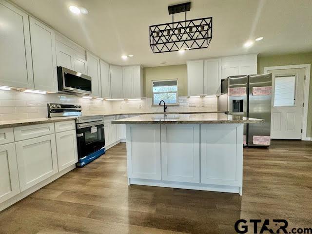 641 N Weldon St, Frankston, TX 75763 - kitchen with appliances with stainless steel finishes, dark wood-style floors, white cabinetry, recessed lighting, and tasteful backsplash