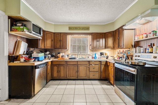 kitchen featuring light countertops, appliances with stainless steel finishes, a sink, and brown cabinets