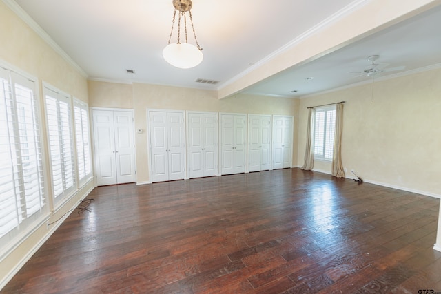 spare room featuring dark hardwood / wood-style floors, crown molding, beam ceiling, and ceiling fan