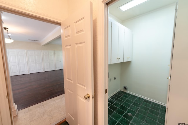 clothes washing area with cabinets, electric dryer hookup, and hardwood / wood-style flooring