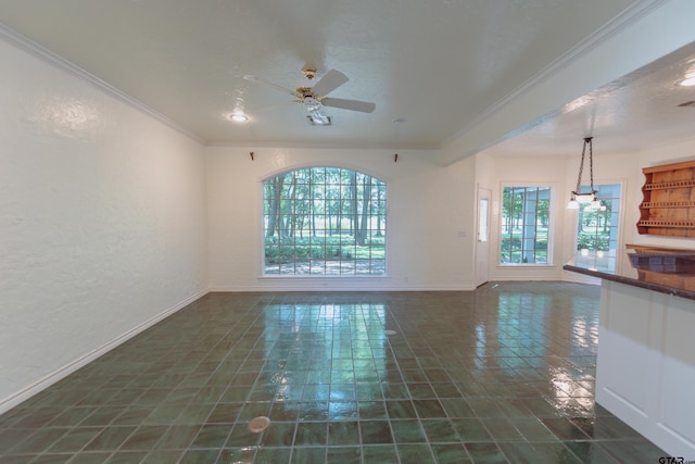 unfurnished living room featuring dark tile patterned flooring, ceiling fan, and crown molding