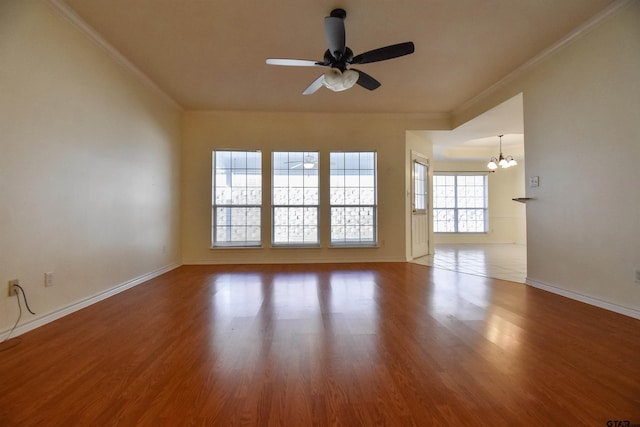 spare room featuring hardwood / wood-style flooring, ceiling fan with notable chandelier, and ornamental molding