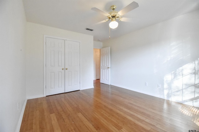 unfurnished bedroom featuring hardwood / wood-style flooring, ceiling fan, and a closet