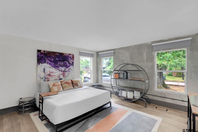 bedroom featuring high vaulted ceiling and light hardwood / wood-style flooring