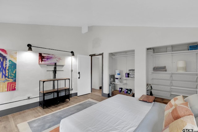 bedroom with hardwood / wood-style flooring and high vaulted ceiling