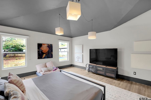 bedroom featuring light wood-type flooring and high vaulted ceiling