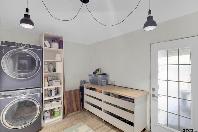 clothes washing area featuring light hardwood / wood-style floors and stacked washer / drying machine