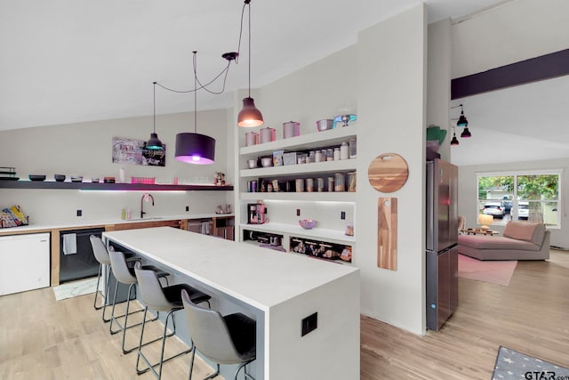 kitchen with black dishwasher, decorative light fixtures, stainless steel refrigerator, and light hardwood / wood-style floors