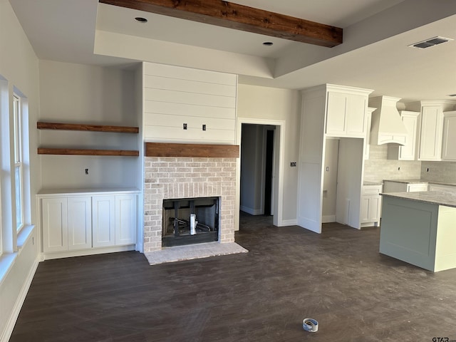 kitchen featuring a brick fireplace, dark hardwood / wood-style floors, custom exhaust hood, and white cabinets