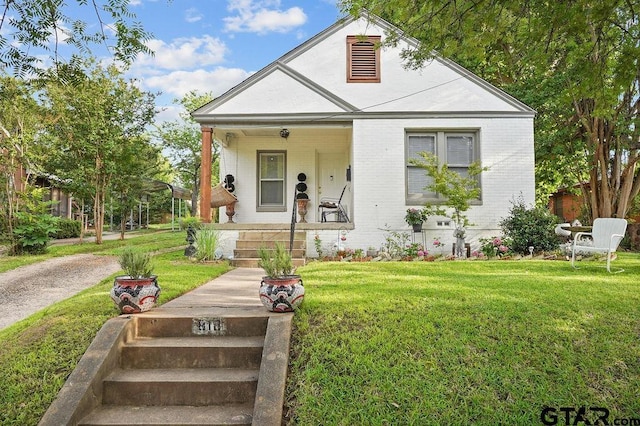 818 Rusk St, Tyler, TX 75701 - view of front of home featuring covered porch, brick siding, and a front lawn
