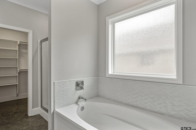 full bathroom featuring a garden tub, a walk in closet, and a shower stall