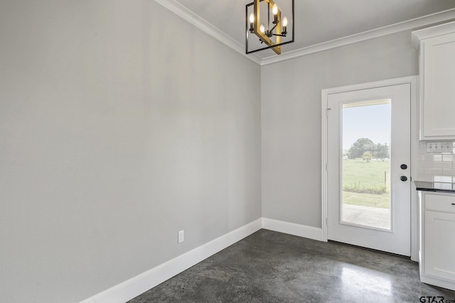 doorway featuring finished concrete flooring, an inviting chandelier, baseboards, and ornamental molding