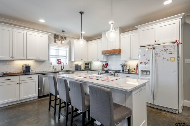 kitchen featuring appliances with stainless steel finishes, a kitchen island, a sink, and a kitchen breakfast bar