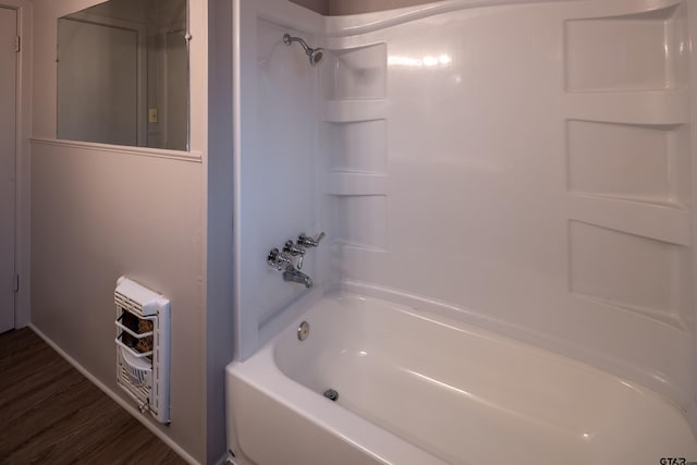 bathroom with heating unit, wood-type flooring, and shower / bathing tub combination