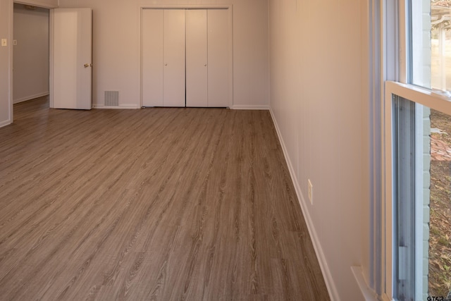 unfurnished bedroom featuring hardwood / wood-style floors and a closet