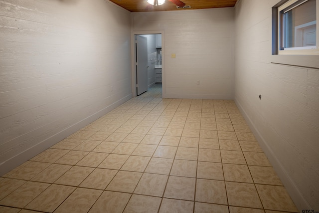 empty room with wooden ceiling and light tile patterned flooring