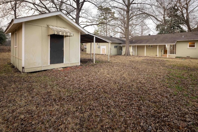 rear view of house featuring a storage shed