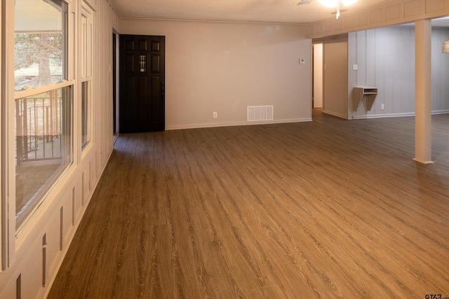 spare room with dark wood-type flooring and crown molding