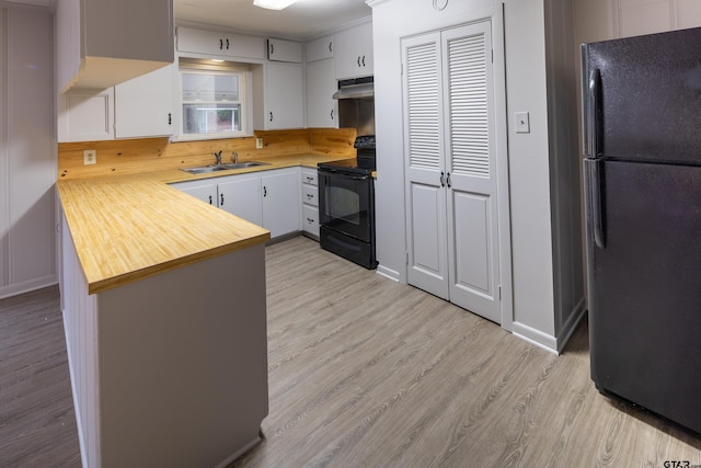 kitchen featuring light hardwood / wood-style flooring, sink, black appliances, kitchen peninsula, and white cabinets