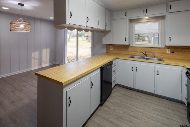 kitchen with sink, white cabinetry, dishwasher, and decorative light fixtures