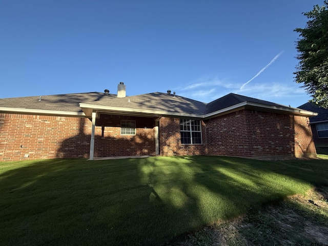 203 Macarthur St, Tyler, TX 75704 - rear view of house with a lawn, brick siding, and a chimney