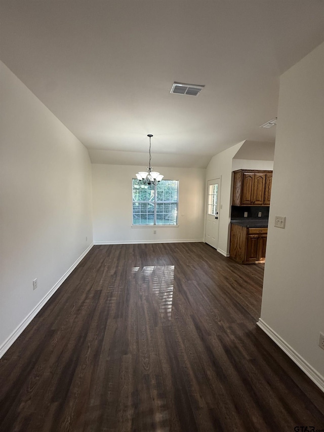 203 Macarthur St, Tyler, TX 75704 - unfurnished dining area with a chandelier, baseboards, dark wood-style floors, and lofted ceiling