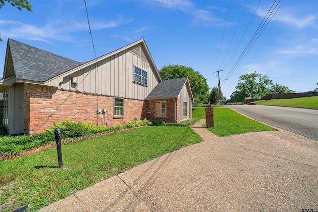 1101 Canada St, Jacksonville, TX 75766 - view of property exterior featuring brick siding, board and batten siding, a yard, and a shingled roof